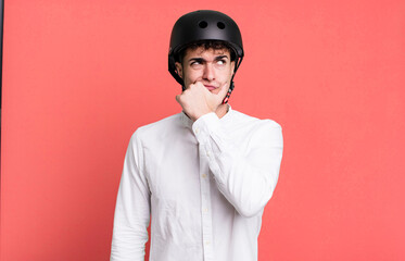 adult man thinking, feeling doubtful and confused. city motorbike rider concept
