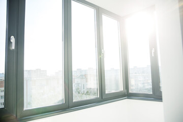 Balcony with black window in flat. Sunlight.