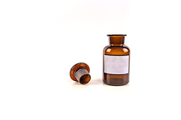Brown medical jar with a glass stopper on a white background with a label