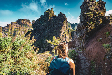 Woman with backpack hiking along scenic hike trail to Pico Ruivo in the late morning. Pico do...
