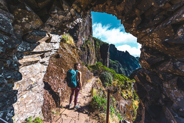 Woman with backpack hiking along scenic hike trail to Pico Ruivo in the late morning. Pico do...