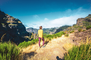 Woman enjoying mountain scenery from very scenic view point along hike trail to Pico Ruivo in the...