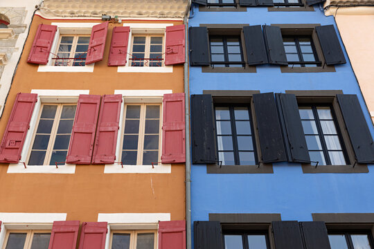 Edificios con ventanas de madera en azul y en rojo.