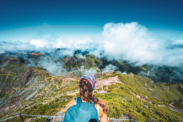 Hiker with backpack enjoying the view of the summit of Pico Ruivo at noon. Pico do Arieiro, Madeira...