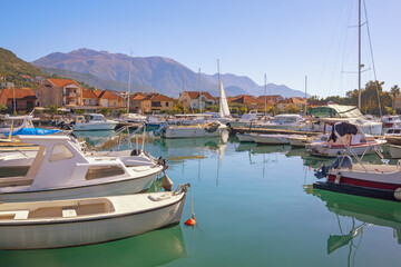 Fototapeta na wymiar Beautiful autumn Mediterranean landscape. Fishing boats in harbor. Montenegro, view of Tivat city and Marina Kalimanj