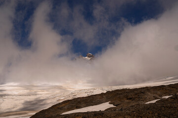 Alpine landscape. View of Tronador hill rocky peak and glacier Castaño Overo snow and ice field under a cloudy sky.