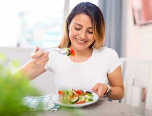Young latino woman have lunch at home eating freshness salad