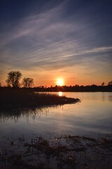 Beautiful summer landscape. The sun setting over the lake.