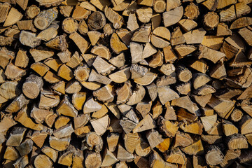 Stacked Logs. Harvested Split firewood in a woodshed stacked in neat piles. Preparation of firewood for blackout. Energy disaster in Ukraine