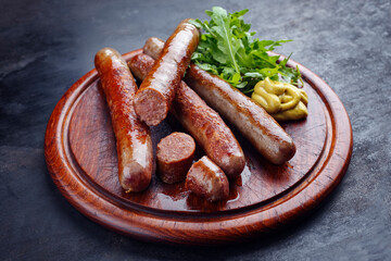 Gebratene Allgäuer Wagyu Rindsbratwurst mit scharfem Senf und Rucola serviert als close-up auf...