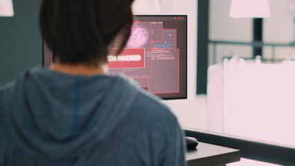 System engineer wokring on server code and reading database error on computer screen, having hacking alert and warning. Dealing with cyber crime attack and hacked system. Handheld shot.