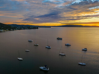 Fototapeta premium Aerial sunrise over the bay with boats and clouds