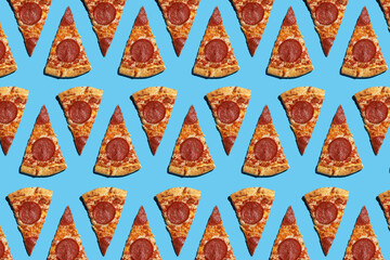 A hard light pattern of cut salami pizza pieces on a seamless bright blue background, top view
