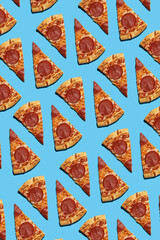 A hard light pattern of cut salami pizza pieces on a seamless bright blue background, top view,...