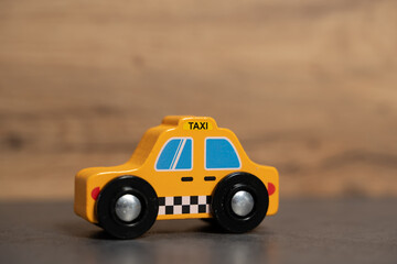 petite voiture en bois taxi jaune avec fond flou