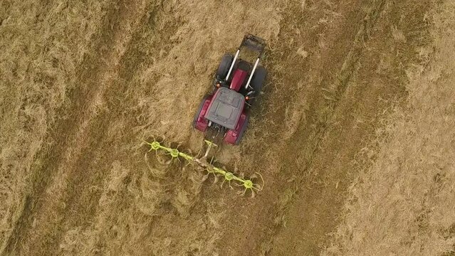 Tractor-drawn Hay Tedder Cutting Hay At The Farm. aerial