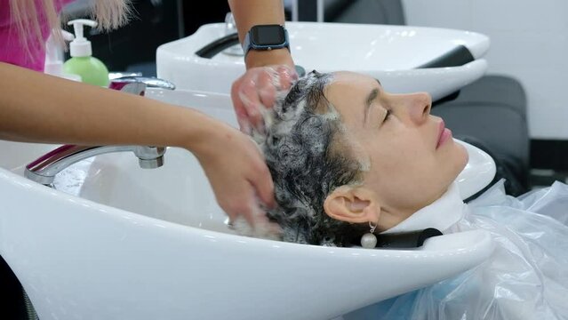 Woman getting hair wash at hairdressing salon