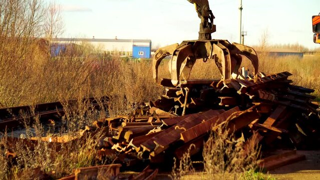 The manipulator loads scrap metal in the recycling center