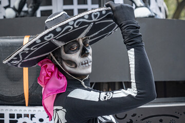 Fototapeta na wymiar Beautiful woman dressed like a death Mexican mariachi. Fancy black costume used for the Day of the Dead in Mexico. 