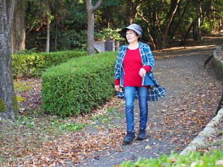 森林公園を歩く高齢日本人女性