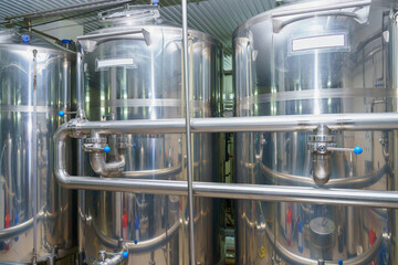 A stainless steel vat in the food industry at a brewery in the process of brewing beer. Background