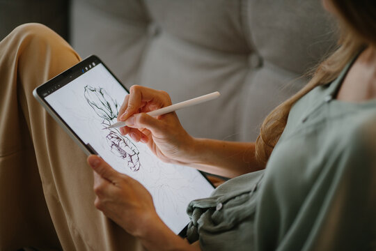 Artist or designer making new project, drawing on a graphic tablet with pencil, close-up on a screen.