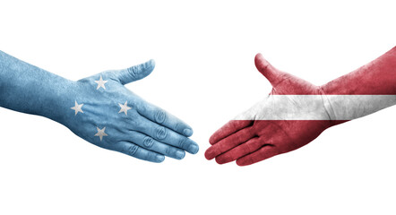 Handshake between Micronesia and Latvia flags painted on hands, isolated transparent image.