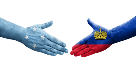 Handshake between Micronesia and Liechtenstein flags painted on hands, isolated transparent image.