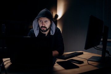Hacker using laptop at dark room