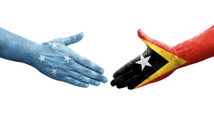 Handshake between Micronesia and Timor Leste flags painted on hands, isolated transparent image.