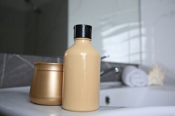 Bottle of shower gel and hair mask on sink in bathroom. Space for text