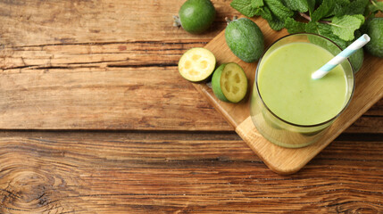 Fresh feijoa smoothie and ingredients on wooden table, flat lay with space for text. Banner design