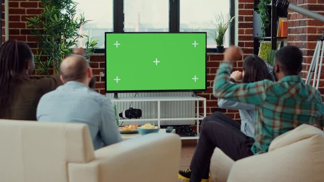 People cheering at football game match on greenscreen, using blank chroma key template to watch soccer team in championship. Sport fans looking at isolated mockup copyspace background.