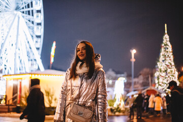 Obraz premium Portrait of young woman standing in city during Christmas at night
