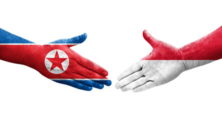 Handshake between Monaco and North Korea flags painted on hands, isolated transparent image.