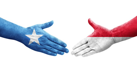 Handshake between Monaco and Somalia flags painted on hands, isolated transparent image.