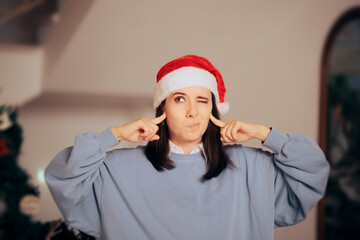 Stressed Woman Covering Her Ears Tired of Christmas Songs. Neighbor annoyed by loud xmas party...