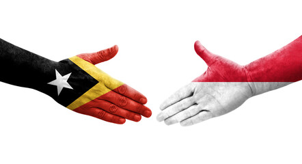 Handshake between Monaco and Timor Leste flags painted on hands, isolated transparent image.