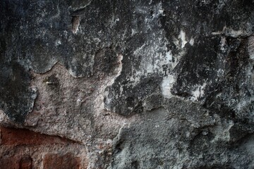 A weathered concrete wall with cracks and peeling paint, showing signs of age and decay.