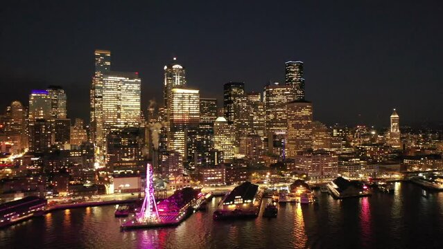 Seattle, Washington, USA - November 2022, nighttime aerial video view  of Seattle Downtown, with the Space Needle, Skyscraper and The Seattle Great Wheel at Waterfront - K4 video night