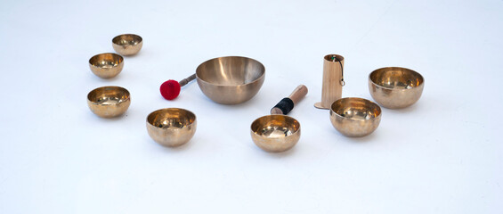 A set of acoustic singing (Tibetan) bowls on a white background with space for text.