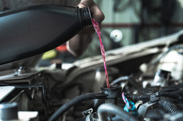 Auto mechanic filling pre-mixed long life coolant fluid in car radiator fill hole.	