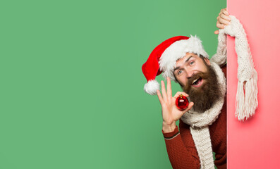 Excited man in Christmas sweater and santa hat. Bearded santa man, christmas card, new year banner with copy space. Happy hipster man in santa hat.