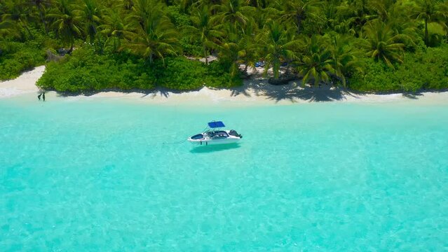 Aerial view of tropical island beach holiday tourist speed boat on blue reef ocean in Maldives