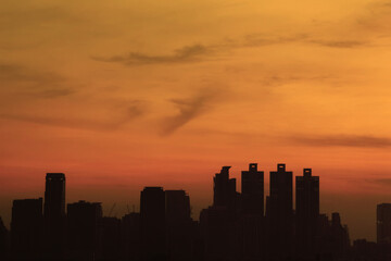 Beautiful skyscape at the sunset time over urban buildings silhouettes