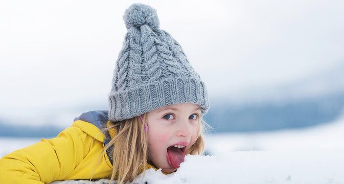 Winter Girl Eating Snow Outdoor. Kids Cold And Flu Concept. Kid Lick Snow With Tongue. Funny Kids Face.