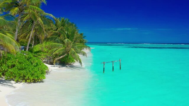 Paradise white sand beach, turquoise ocean, green palm trees and blue sky with clouds on a sunny day in island Thoddoo in Maldives. Summer tropical landscape, aerial panoramic view