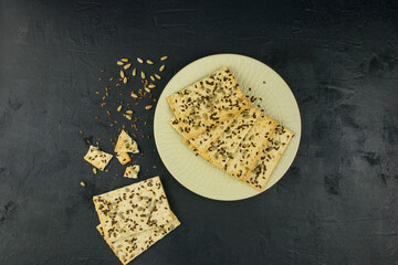 a sugar-free whole-grain flour on a light plate of sesame and flax seeds. top view. black...