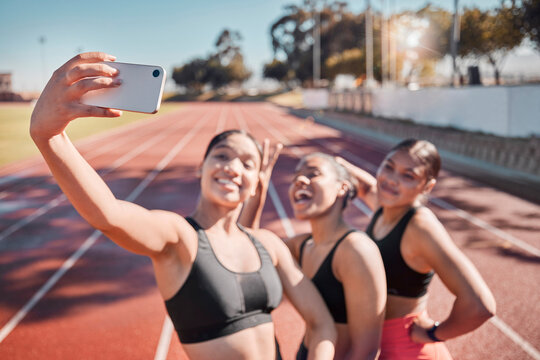 Fitness, friends and selfie by runner women group at a running track for training, exercise and cardio wellness. Sports, phone and girl team smile, relax and pose for picture after stadium workout