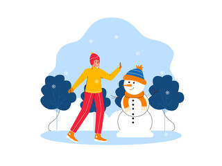 People making snowman, winter outdoor recreation.  Snowman wearing hat and scarf.